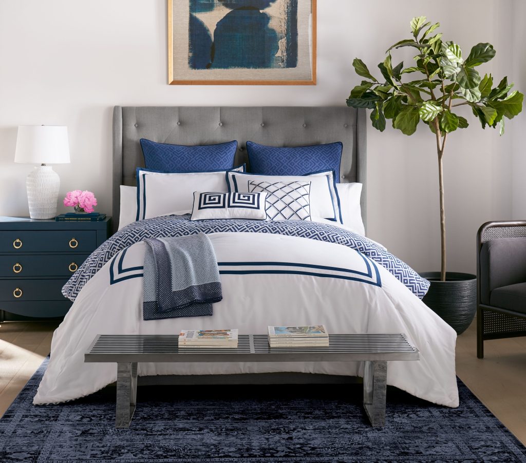 Grand Floridian blue and white bedset in the Sobel Disney Resorts Home Collection displayed in hotel bedroom setting