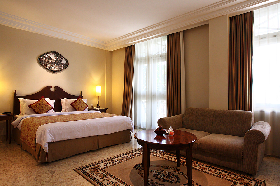 Large cozy bedroom hotel linen with browns and earth tone accents.