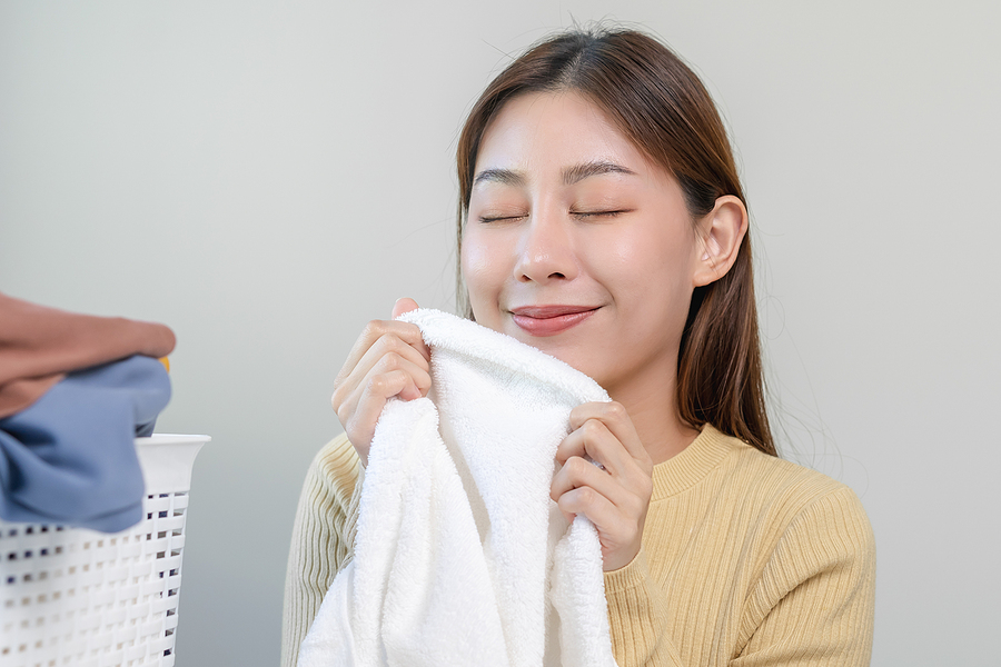Asian woman smelling fresh white towels