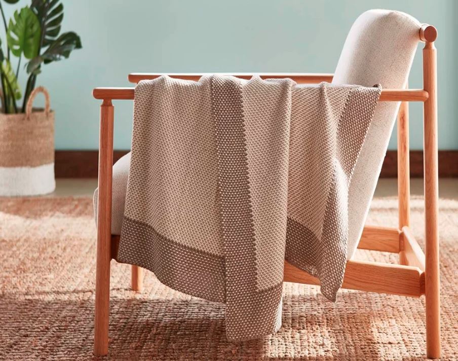 sand colored cozy throw blanket draped over chair