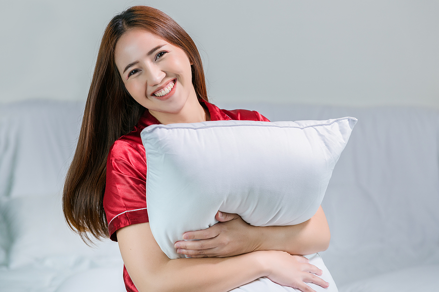 woman hugging a soft down pillow